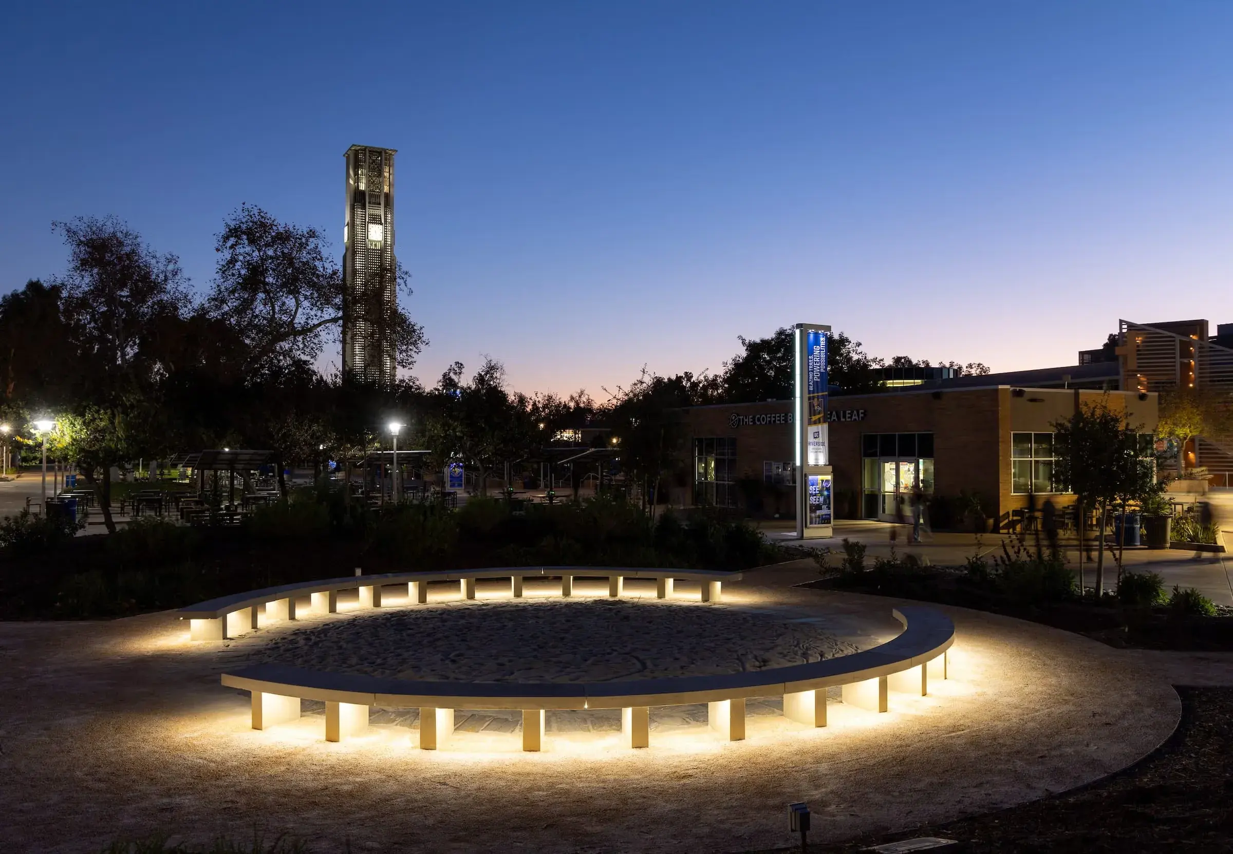 The Native American Student Programs garden lit at dusk, the bell tower behind it