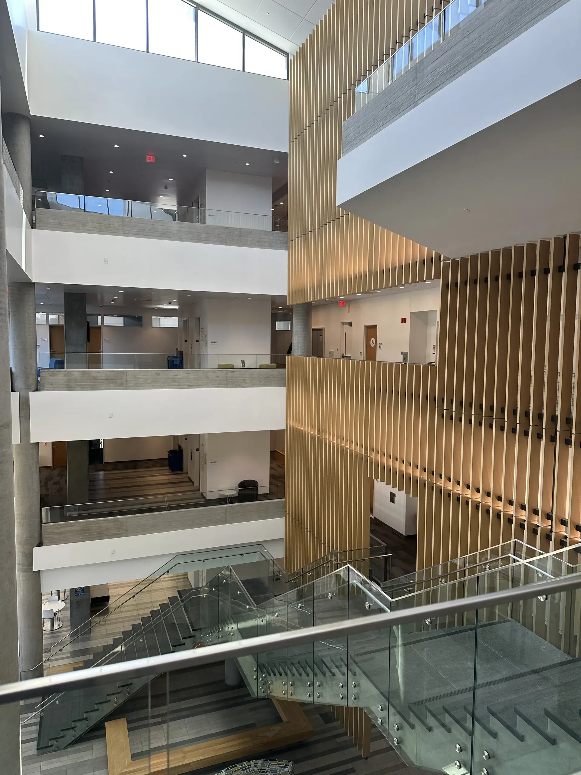 The building's full-height atrium, walkways on three levels behind a timber screen