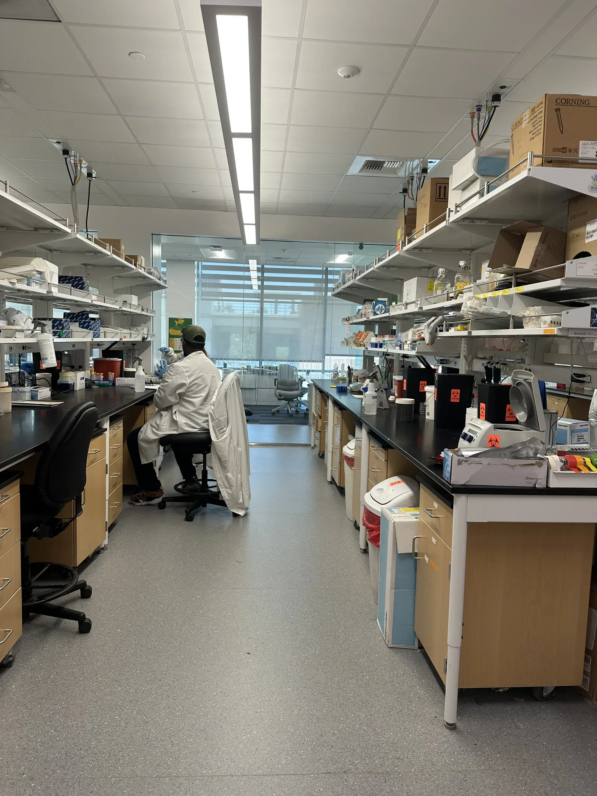 A bench aisle running toward a window, work stations along both sides